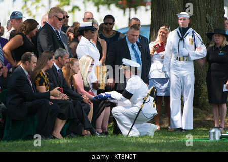 Erin Elizabeth Rehm receives the American flag from Vice Adm. Jan Tighe, Deputy Chief of Naval Operations for Information Warfare and Director of Naval Intelligence, during the graveside service for her husband, U.S. Navy Fire Controlman Chief Gary Leo Rehm Jr. at Arlington National Cemetery, Arlington, Va., Aug. 16, 2017. Rehm perished when the USS Fitzgerald (DDG 62) was involved in a collision with the Philippine-flagged merchant vessel ACX Crystal on June 17, 2017. The U.S. Navy posthumously promoted Rehm to Fire Controlman Chief in a ceremony earlier this week. (U.S. Army photo by Elizabe Stock Photo