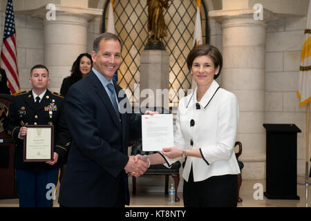 Katharine Kelley, right, superintendent, Arlington National Cemetery, receives the Secretary of the Army’s letter from Gerald B. O’Keefe, administrative assistant to the Secretary of the Army, during her Senior Executive Service induction ceremony, March 2, 2017, in Arlington, Va. The ceremony took place in the lower level of the Memorial Amphitheater in the cemetery. (U.S. Army photo by Rachel Larue/Arlington National Cemetery/released) Stock Photo