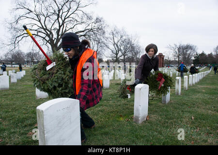 Karen Durham-Aguilera, left, executive director of Army National Military Cemeteries, and Katharine Kelley, right, superintendent, Arlington National Cemetery, pick up wreaths during Wreaths Across America’s Wreath Retirement Day at ANC, Jan 28, 2017, in Arlington, Va. In mid-December, volunteers with WAA placed a wreath on each gravesite in the cemetery. (U.S. Army photo by Rachel Larue/Arlington National Cemetery/released) Stock Photo