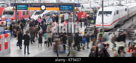 Munich, Germany. 23rd Dec, 2017. Travellers walk across a platform at the Hauptbahnhof (main station) in Munich, Germany, 23 December 2017. Many people are making their way to their families at the start of the Christmas holidays. (Photo taken with long exposure time) Credit: Tobias Hase/dpa/Alamy Live News Stock Photo