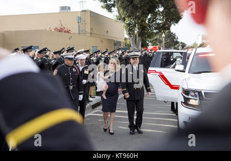 San Diego, California, USA. 23rd Dec, 2017. Wife ASHLEY IVERSON and daughter Evie are escorted by CAL FIRE at the celebration of life of Cory Iverson who was killed battling the Thomas Fire at the Rock Church in San Diego on Saturday December 23, 2017. Credit: Kevin Warn/ZUMA Wire/Alamy Live News Stock Photo