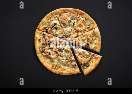 Fresh italian pizza with mushrooms, tomatoes, cheese, on black stone background Stock Photo