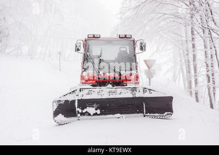 Front view of a snowy snow plow in winter on a foggy day, Vosges, France. Stock Photo