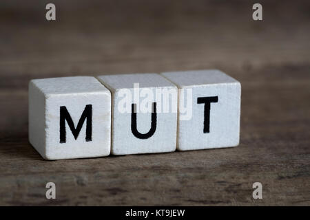 German word courage, written in cubes on a wooden background Stock Photo