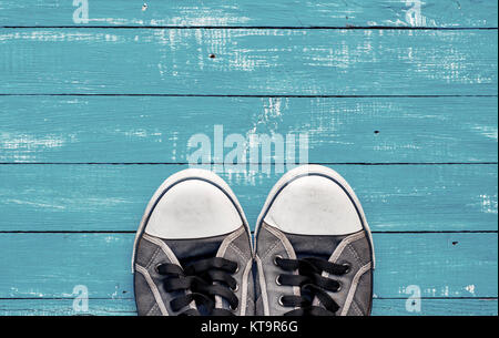 Blue men's old shabby sneakers on a blue wooden surface Stock Photo