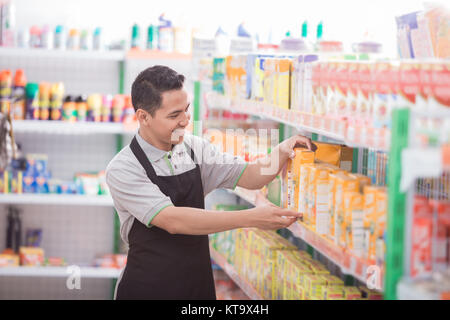 asian male shopkeeper working in a grocery store Stock Photo