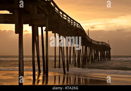 NC01147-00...NORTH CAROLINA - Colorful sunrise on a cloudy day at Avon Fishing Pier along the Outer Banks on Hatteras Island. Stock Photo