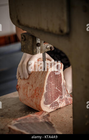 Butcher is slicing beef meat