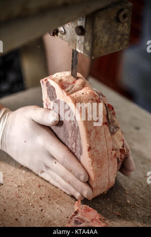 Butcher is slicing beef meat