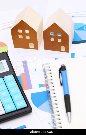 Miniature model of house on chart printed documents, notebook and pen Stock Photo