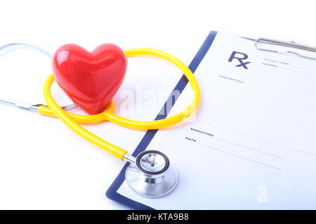 A heart with a medical stethoscope, isolated on wooden background Stock Photo