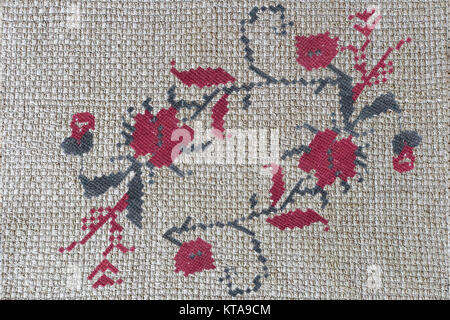 Needlework: embroidered criss-cross pattern of beautiful flowers on canvas. Handmade. Stock Photo