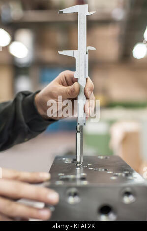 Repairer using accurate ruler for measuring in workshop. Close up Stock Photo