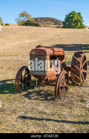 Old rusted tractor sitting in an open field in San Luis Obispo County, California. Stock Photo