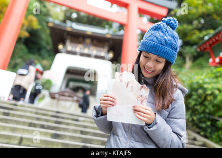 Woman enjoy her squid cracker in Enoshima of Japan Stock Photo