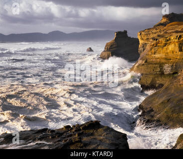 Evening light warmth on the stormy surf at Cape Kiwanda State Park on Oregon’s north coastline and Tillamook County. Stock Photo