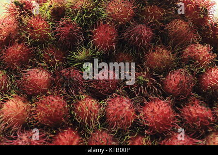 Bunch of rambutan fruits piled together in a stall on the ground floor fronting the sidewalk of Leveriza Street on the outer side of San Andres Market Stock Photo