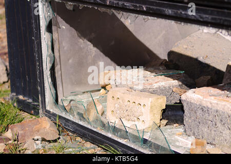 An old vending machine fly tipped and vandalized, with broken glass showing. Stock Photo