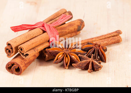 Cinnamon sticks and anise stars on wooden plank Stock Photo