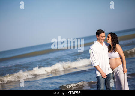 Couple at the beach waiting for their baby - 28 weeks Stock Photo