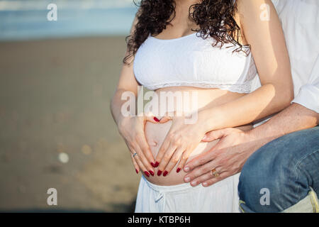 Couple at the beach waiting for their baby - 28 weeks Stock Photo