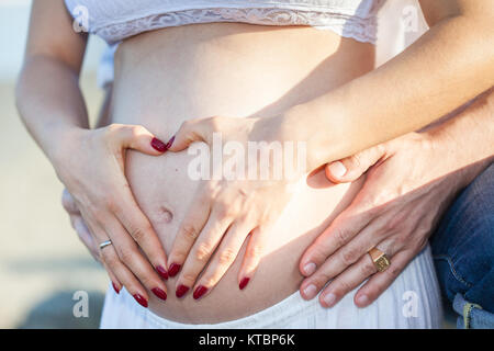 Couple at the beach waiting for their baby - 28 weeks Stock Photo