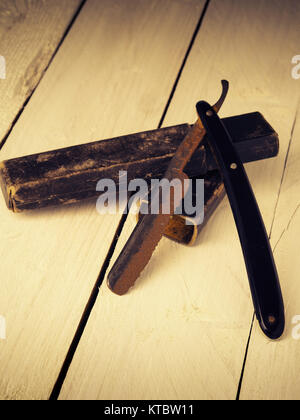 Old and rusty razor on a rustic workbench with space for text or image Stock Photo