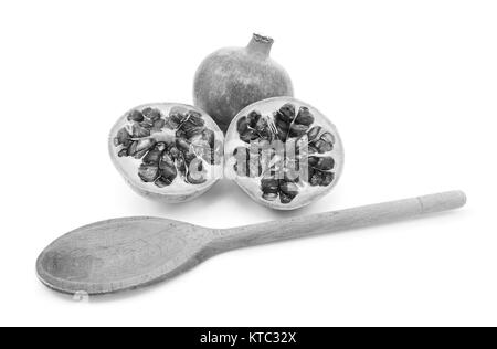 Pomegranate with two cut halves, with spoon for removing seeds Stock Photo