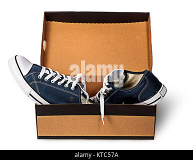 Dark blue sports shoes abandoned in a cardboard box Stock Photo