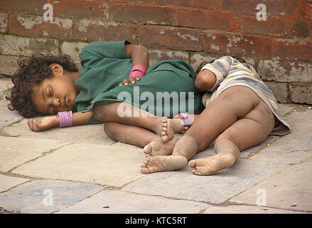 A homeless child is sleeping in the street of New Road, Kathmandu, Nepal Stock Photo