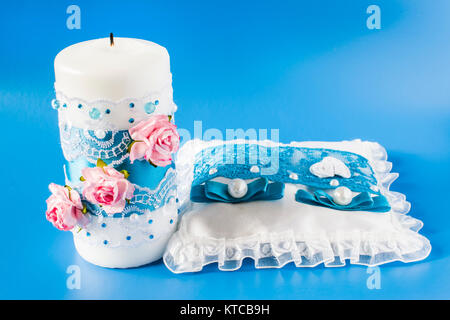 pillow for rings and a wedding candle on a blue background Stock Photo