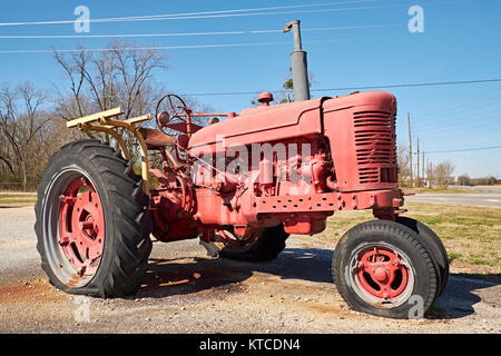 Old vintage red 1950's International Harvester, IH, farm tractor, unrestored, as a roadside display in Cecil Alabama, USA. Stock Photo