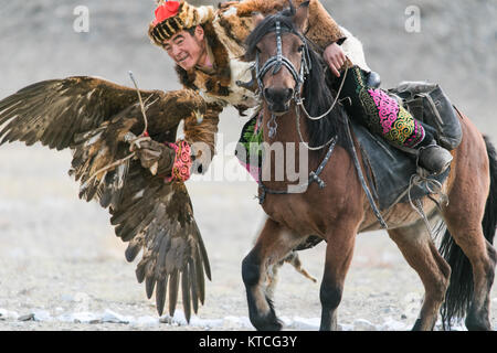 Kazakh eagle hunter on horseback during Golden Eagle Festival in Mongolia Stock Photo