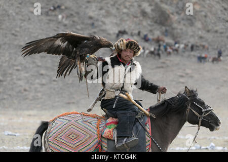 Kazakh eagle hunter on horseback competing at the Golden Eagle Festival in Mongolia Stock Photo