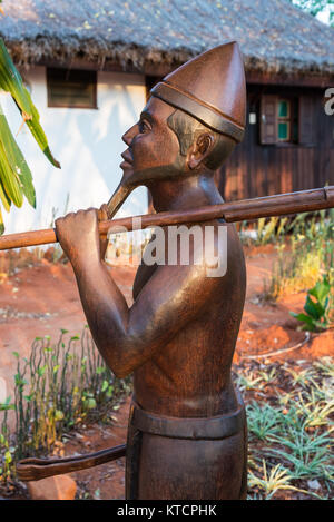 Wood carving of a Malagasy man carrying a gun over his shoulder. Madagascar, Africa. Stock Photo