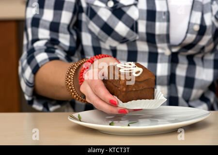 Female hand holding a chocolate cake Stock Photo