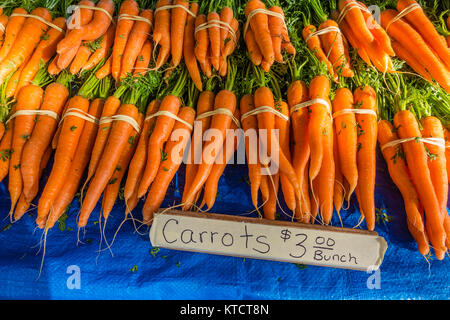 Carrots for sale at a vendor's stall at the Santa Barbara farmer's market vegetables. The carrot (Daucus carota subsp. sativus) is a root vegetable, u Stock Photo