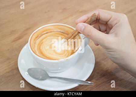Hand On Hot Cup Of Coffee Latte Stock Photo