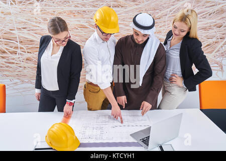 business people group on meeting and presentation in bright modern office with construction engineer architect and worker looking building model and b Stock Photo