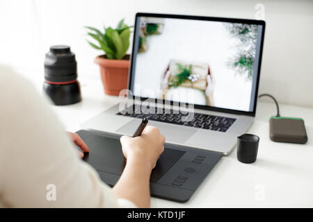 retouching on computer laptop using digital tablet and stylus pen Stock Photo