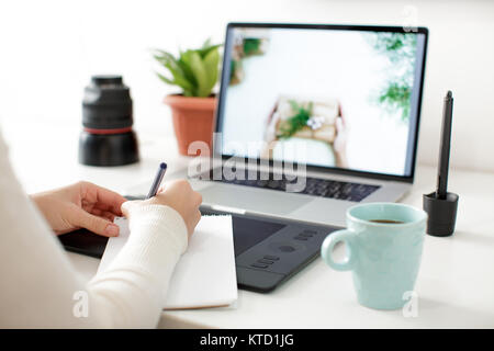 retouching on computer laptop using digital tablet and stylus pen Stock Photo