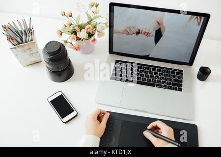 retouching on computer laptop using digital tablet and stylus pen Stock Photo