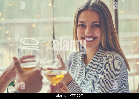 leisure, celebration, drinks, people and holidays concept - happy couple and friends clinking glasses of wine at restaurant Stock Photo
