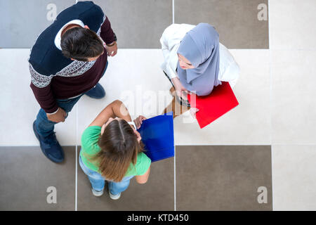 diverse group of students standing discussing school and projects, teamwork, concept Stock Photo