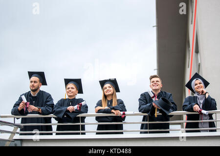 Group of Diverse International Graduating Students Celebrating, sitting and standing, concept Stock Photo