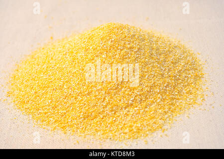 Pile of corn grits on coarse cloth close-up Stock Photo
