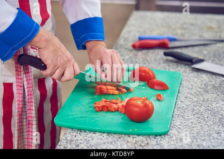 Chef sprinkling spices on dish in commercial kitchen Stock Photo