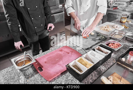 Chef sprinkling spices on dish in commercial kitchen Stock Photo