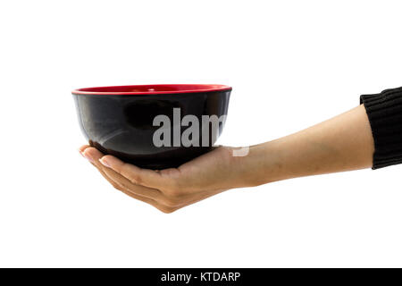 Female hand holding empty black bowl isolated on white background with clipping path for graphics, cut out, editing. A bowl is a round, container used Stock Photo