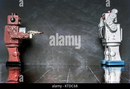 concept gun crime with retro toy robots on a wooden floor Stock Photo